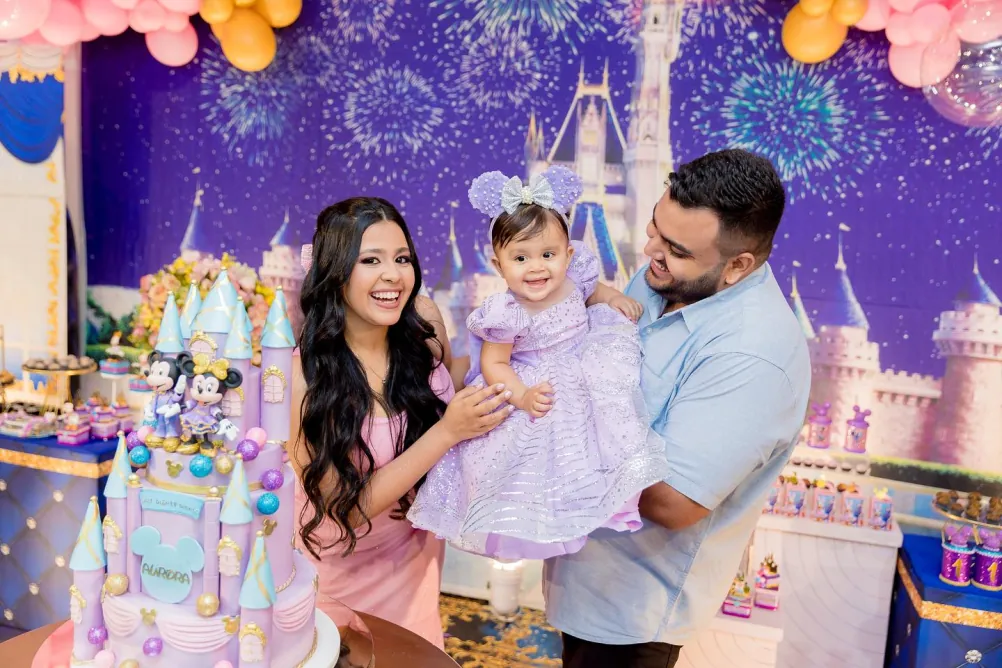 Casal com a filha em festa de aniversário com tema de castelo