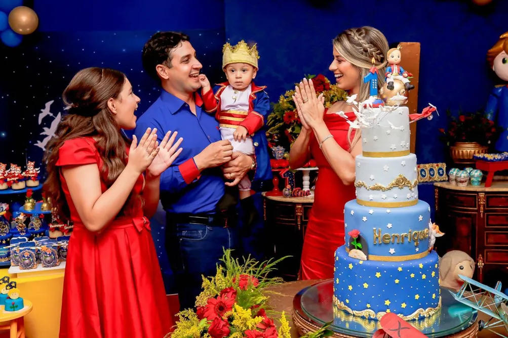 Família comemorando aniversário infantil diante do bolo