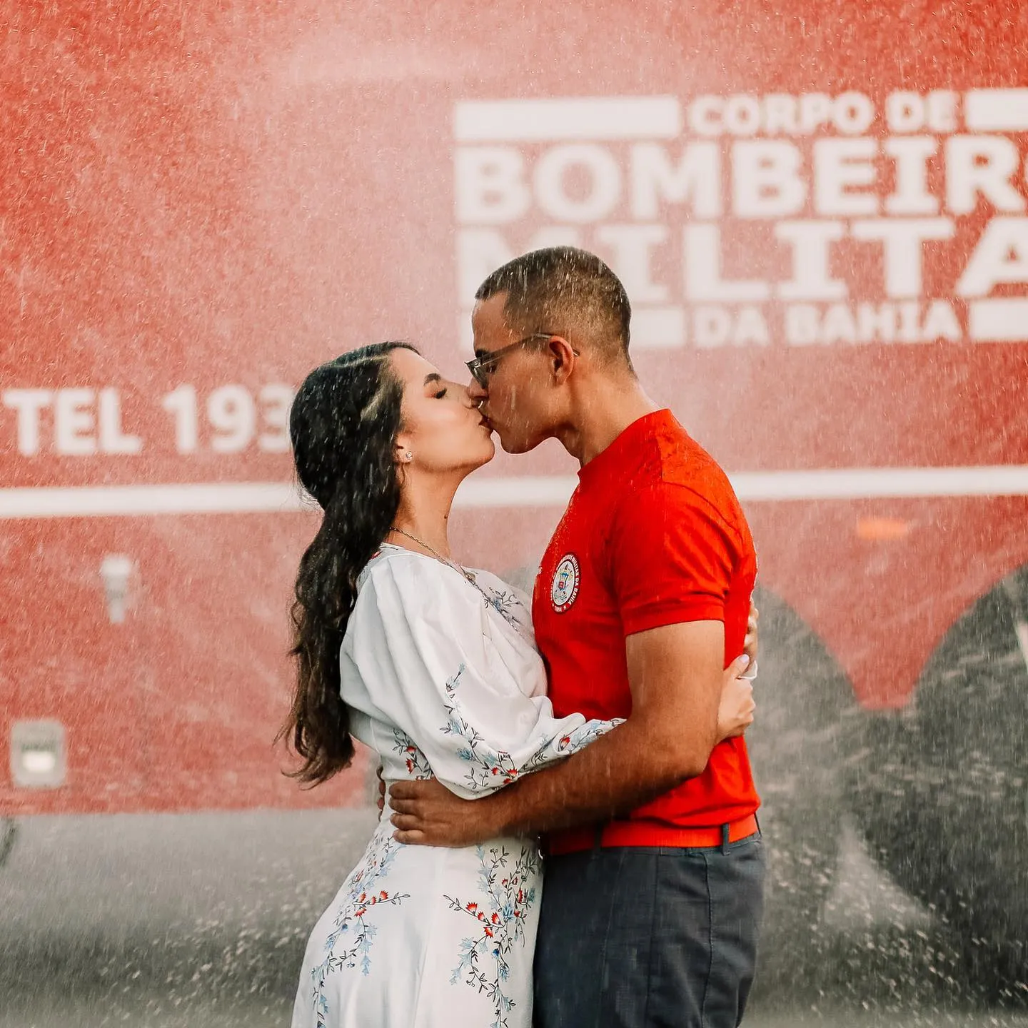 Casal se beijando em frente a um caminhão do Corpo de Bombeiros