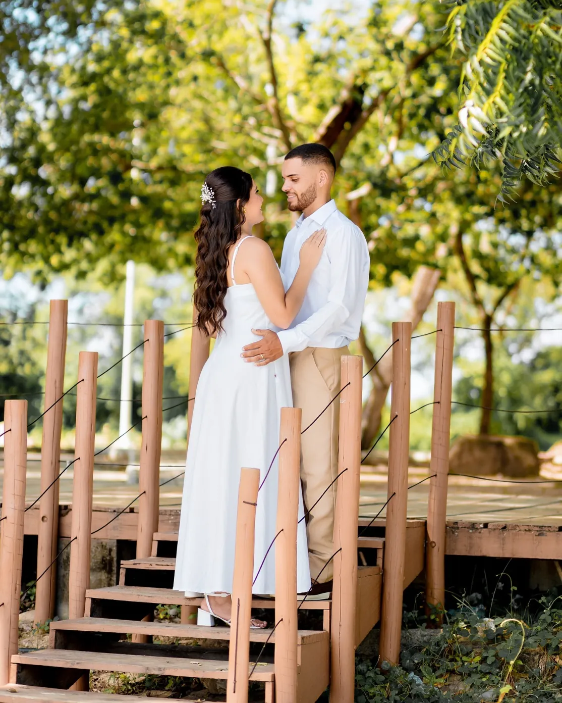 Casal abraçado em uma escada de madeira ao ar livre